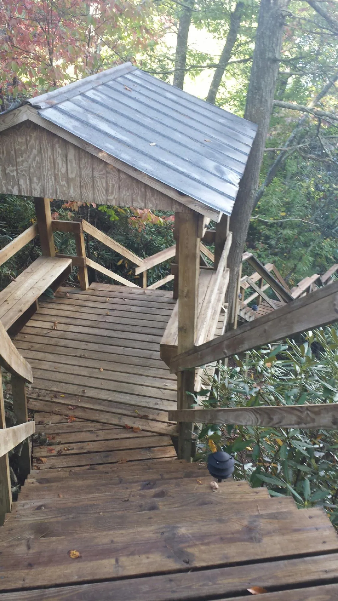 Metal roofed shelter over wooden steps on a wooded walkway — Skylight Repair & Installation work by our crew in Sherrard