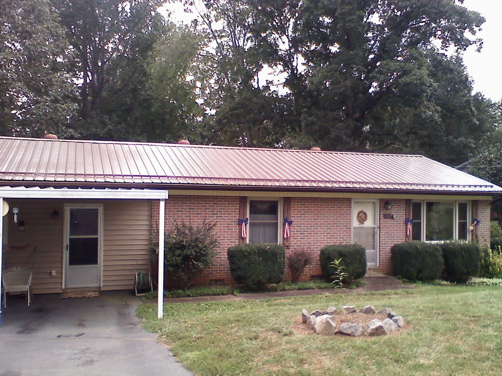 Bronze metal roof and carport on a brick ranch home — Roof Repair work by our crew in Sherrard